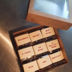 Uma Caixa Brownies Personalizados Dia do Amigo aberta e sobre uma mesa de alumínio