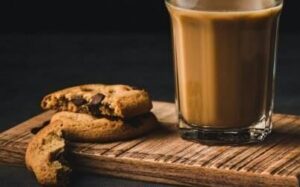 Cookie sobre a mesa e um copo de café com leite